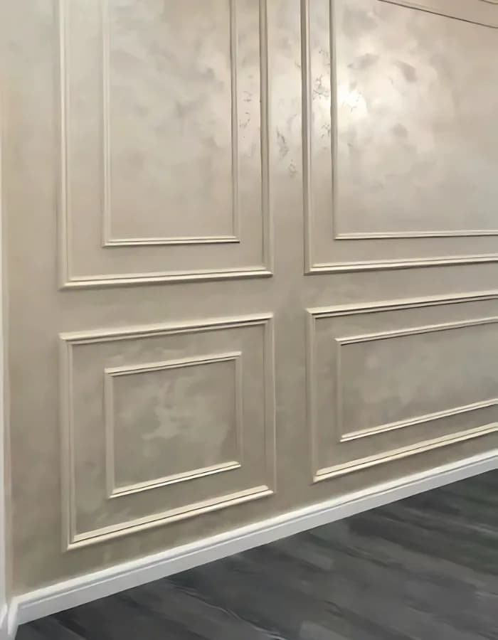 Living room wall finished with decorative moulding and panels