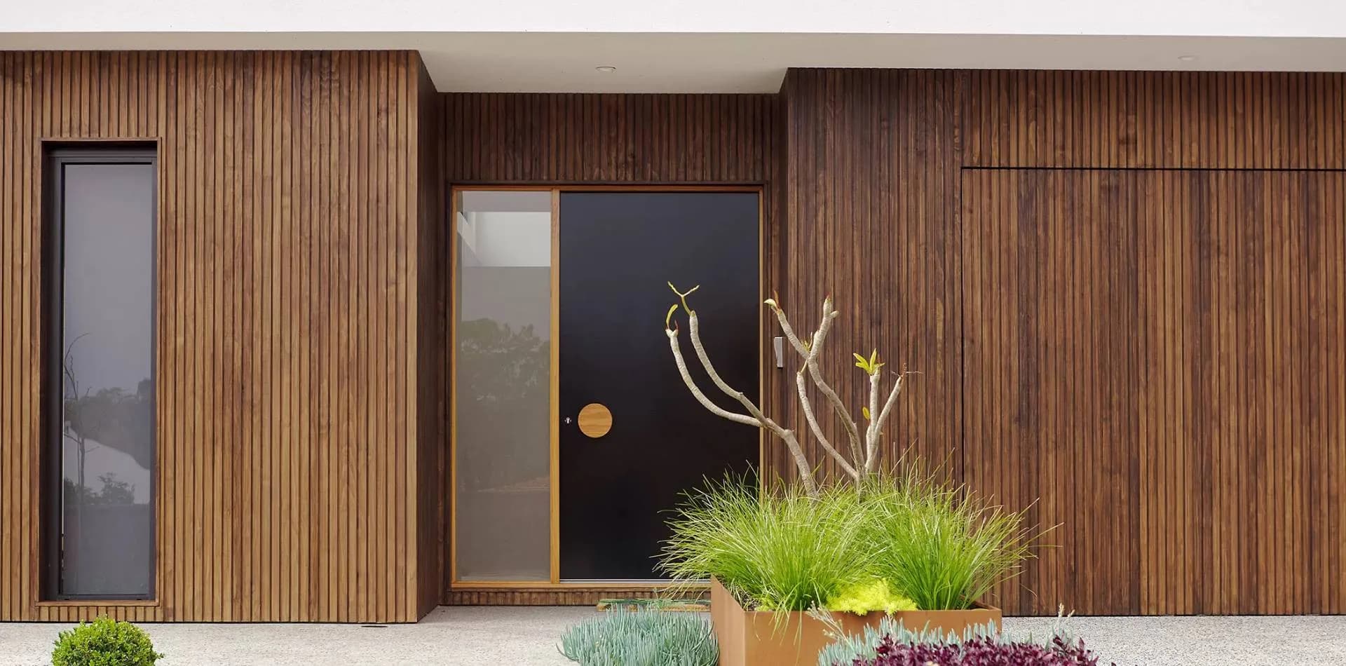 Vertical timber-slatted facade with a black front door