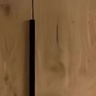 Close-up of a black vertical bar handle on an oak veneer shutter