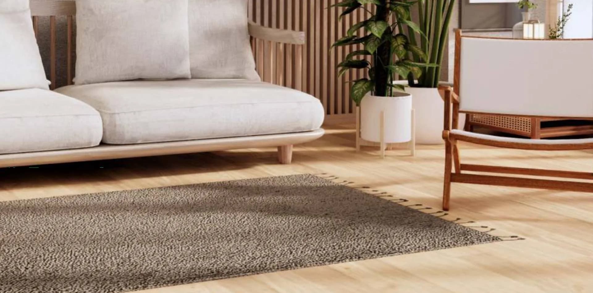 Light plank wood floor in a living room with a cream sofa and a rug