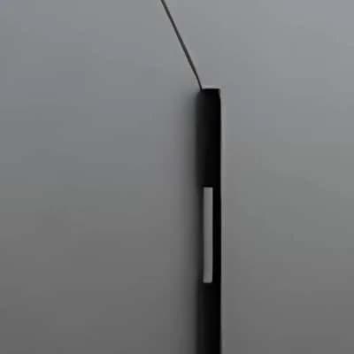 Close-up of a black bar handle with a light inset on a grey shutter