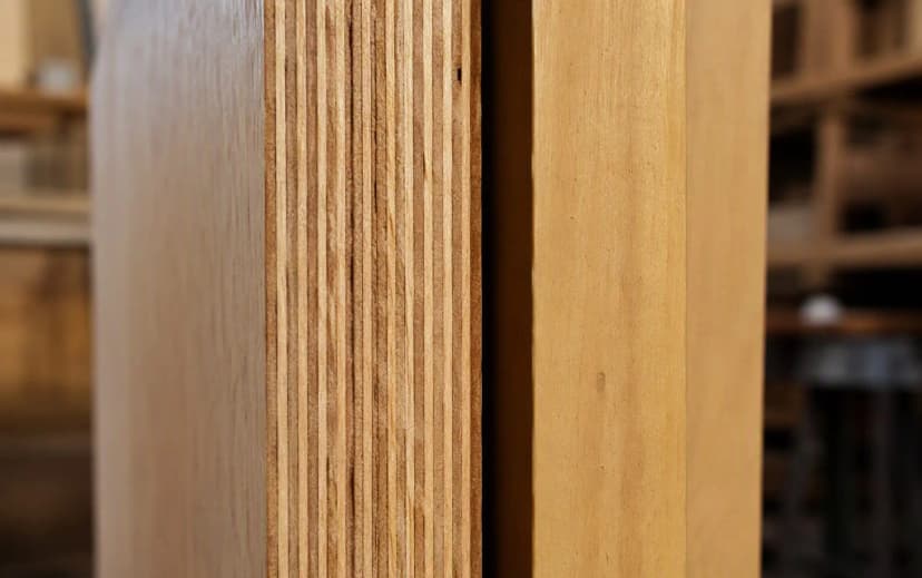 Close-up of a plywood sheet edge showing many thin, uniform, tightly-bonded hardwood veneer layers — a sign of quality construction
