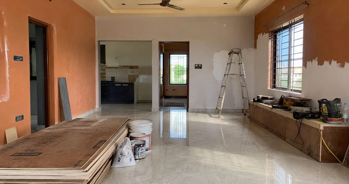 Indian home living room mid-renovation with plywood sheets, paint buckets and ladder